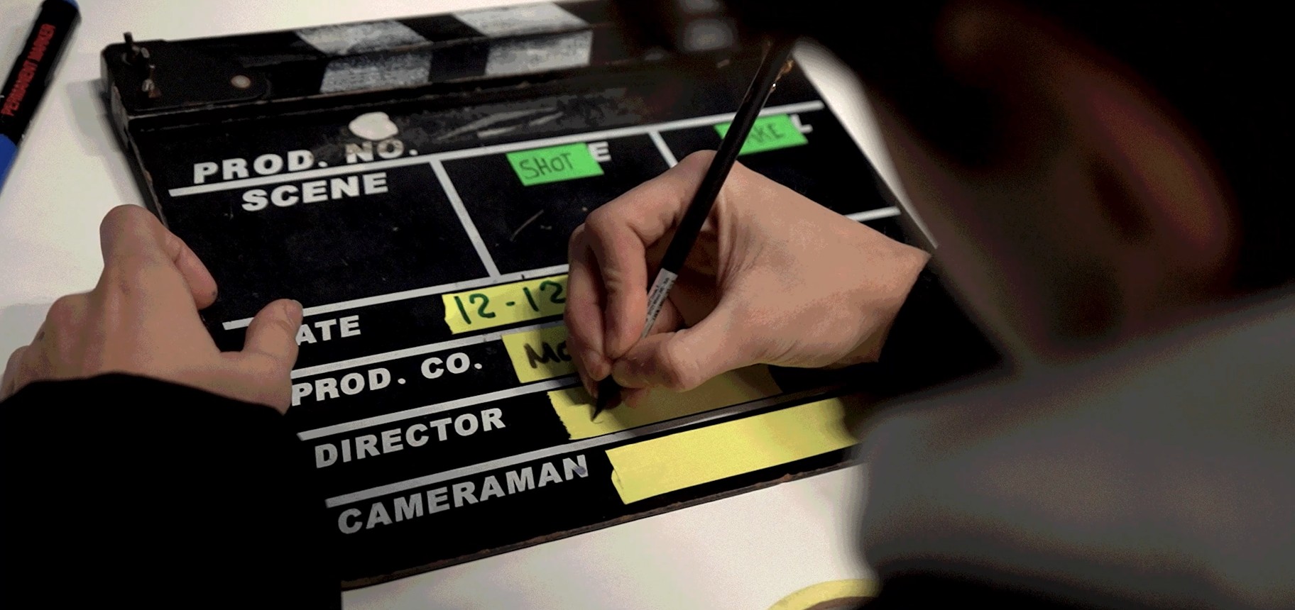 Uno studente di cinema prepara il ciak durante le riprese dei videoclip.